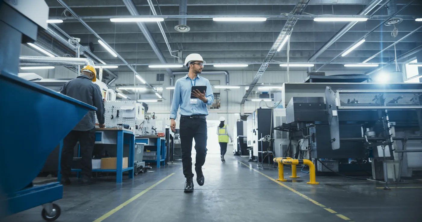 Expediter reviewing production progress at a supplier facility